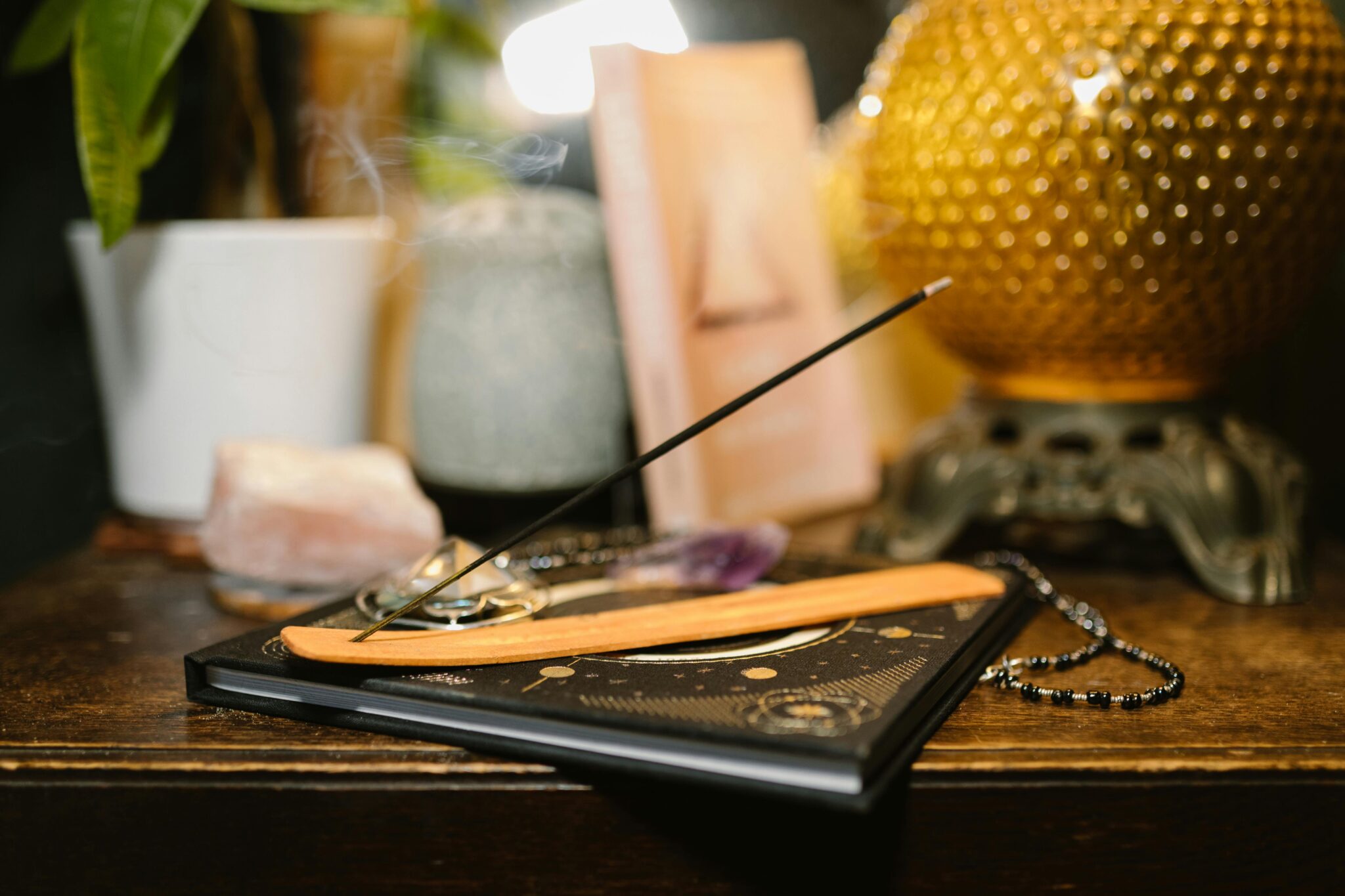 A tranquil setting featuring incense, crystals, and a glowing lamp for spiritual rituals.